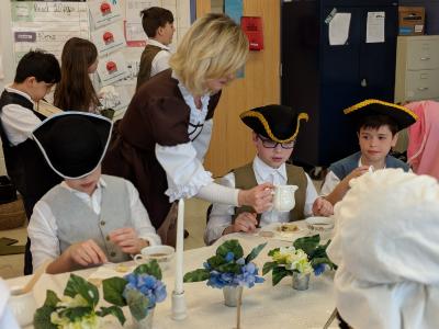 students wearing colonial outfits while participating in colonial activities