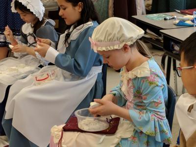 students wearing colonial outfits while participating in colonial activities