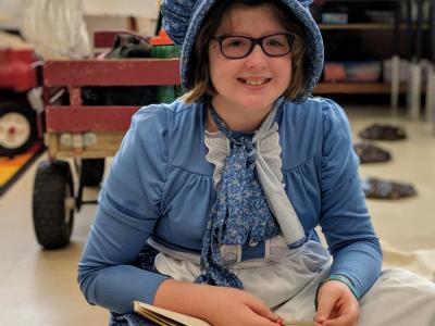 image of student dressed up for Pioneer Day while working on activities