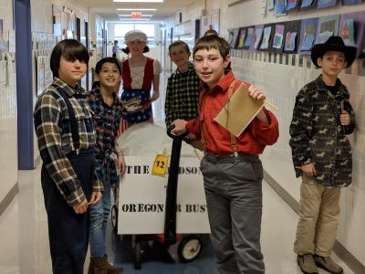 image of students dressed up for Pioneer Day while working on activities