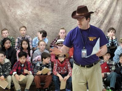 image of students and counselor dressed up for Pioneer Day while working on activities